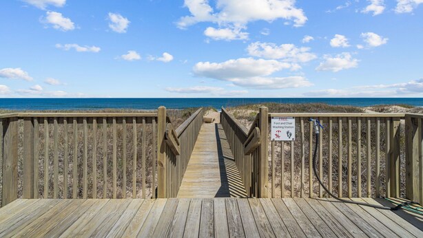 A wooden boardwalk leading to a beach with a sign indicating a free washroom and chair. - 5381- Sol-T-Escape - Wake to Ocean Views | Oceanfront KDH Condo (Kill Devil Hills)