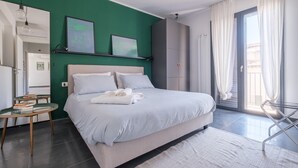 A modern bedroom with a bed, a small table, and a wardrobe.