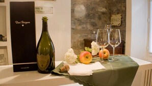 Een fles Dom Pérignon champagne, twee glazen en appels op een tafel met een groene tafelkleed.