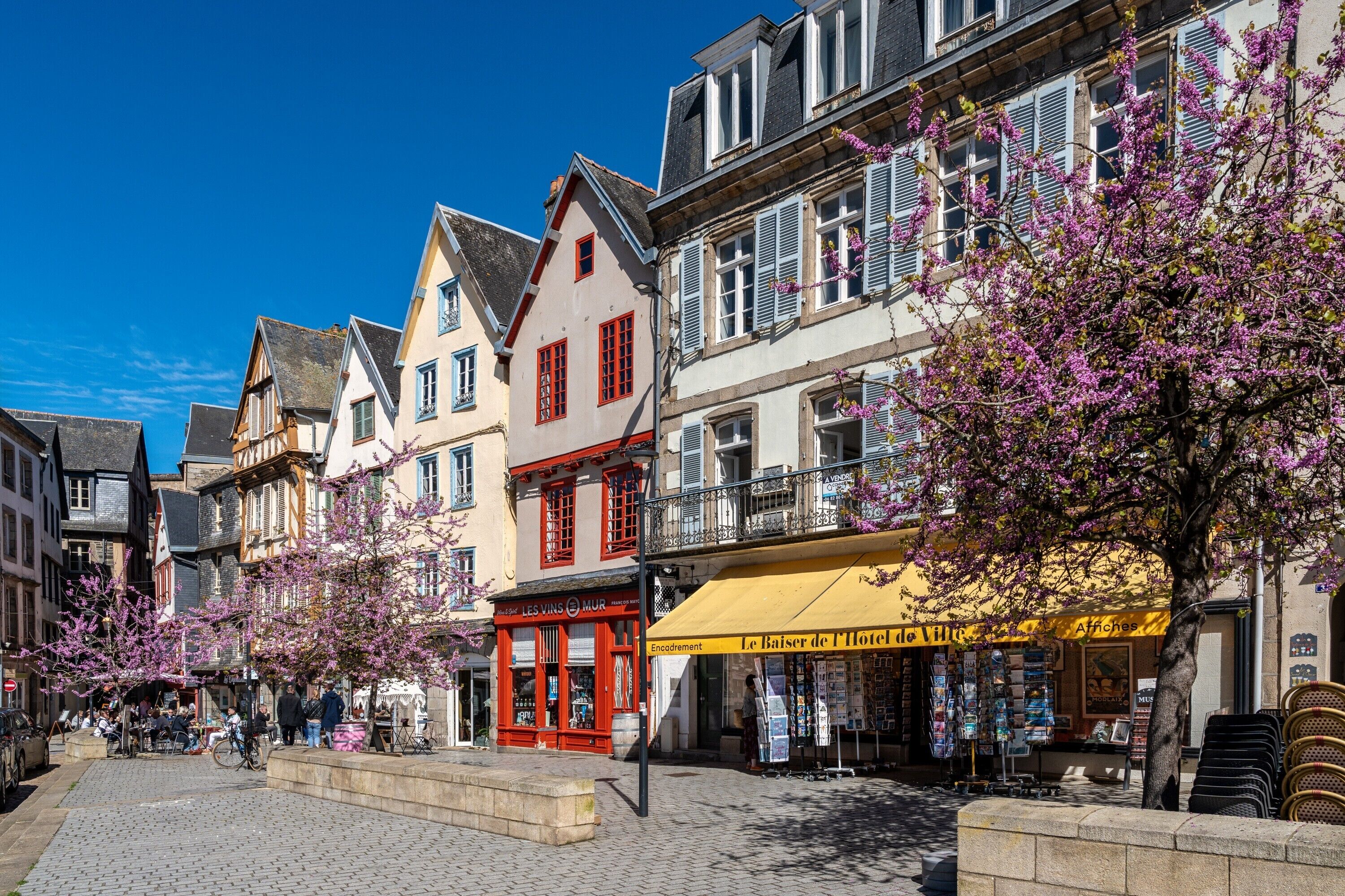 Eine Straße mit historischen Gebäuden, einem Café und einer Buchhandlung.