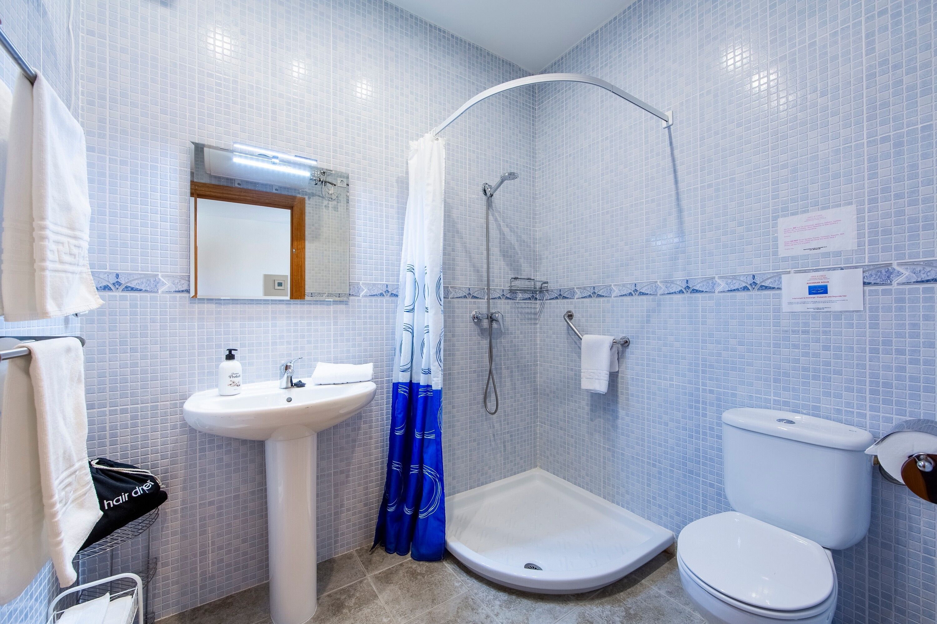 Ein Badezimmer mit Waschbecken, Toilette, Dusche und Handtuchhalter.