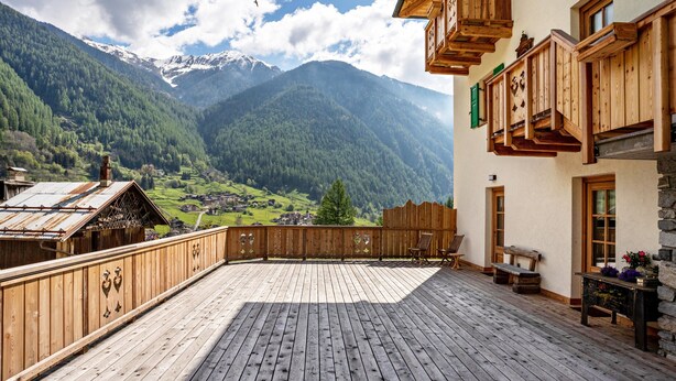 A wooden deck with a view of a mountainous landscape. - 'Volo Dell'aquila' Apartment with Private Sauna and Mountain Views (Rabbi)