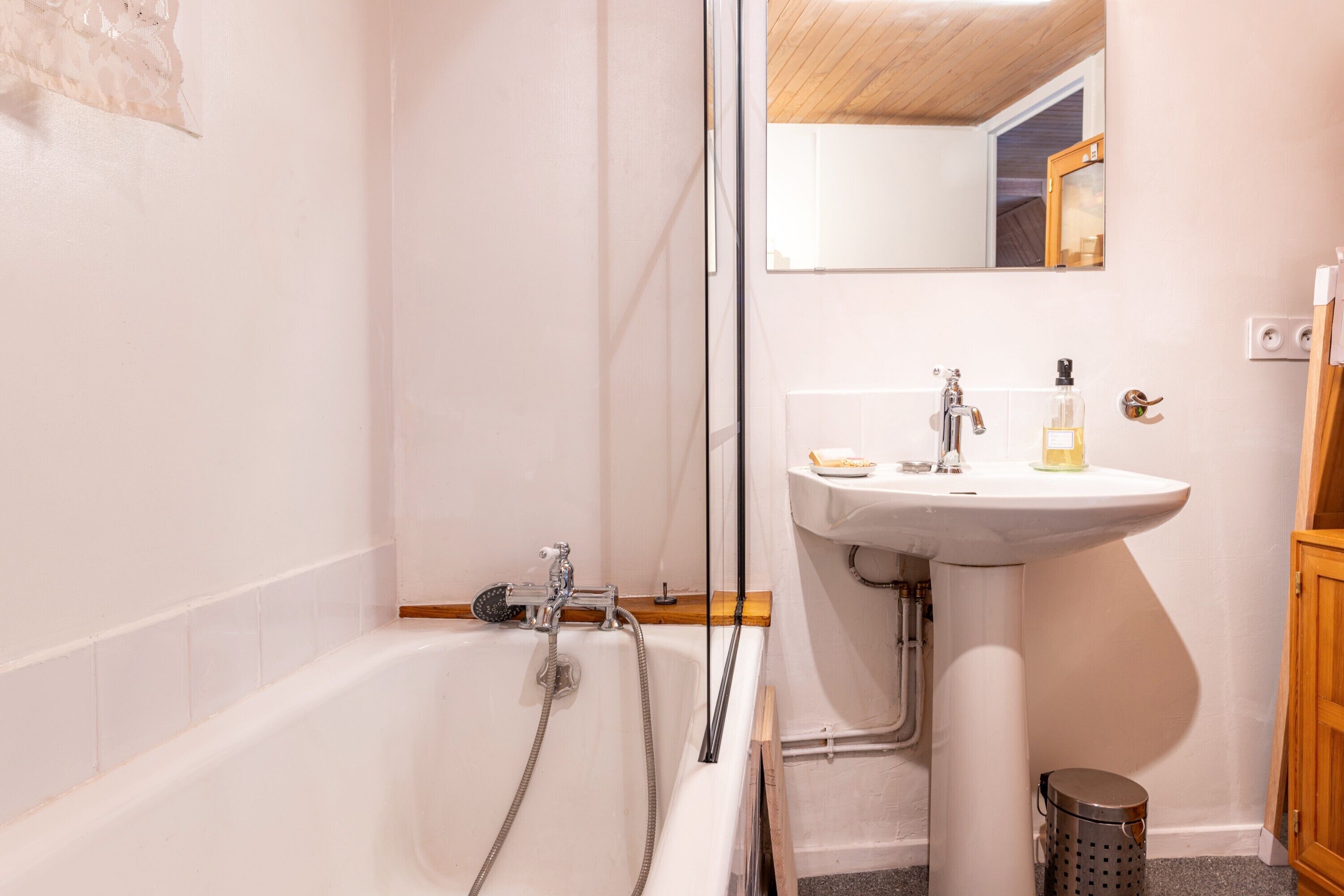 Een badkamer met een bad, een wastafel en een spiegel.