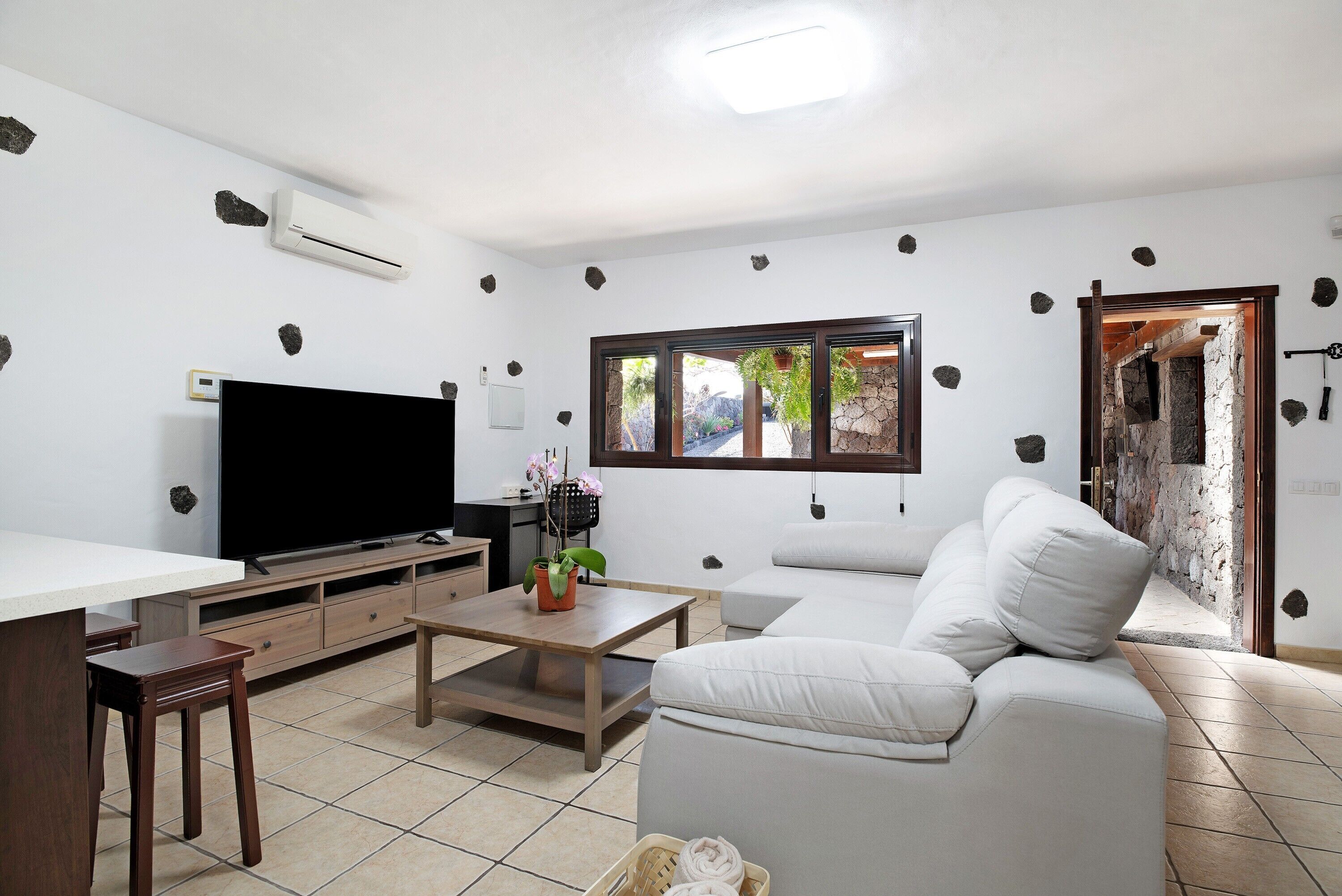 A living room with a flat-screen TV, a sofa, a coffee table, and a TV stand.