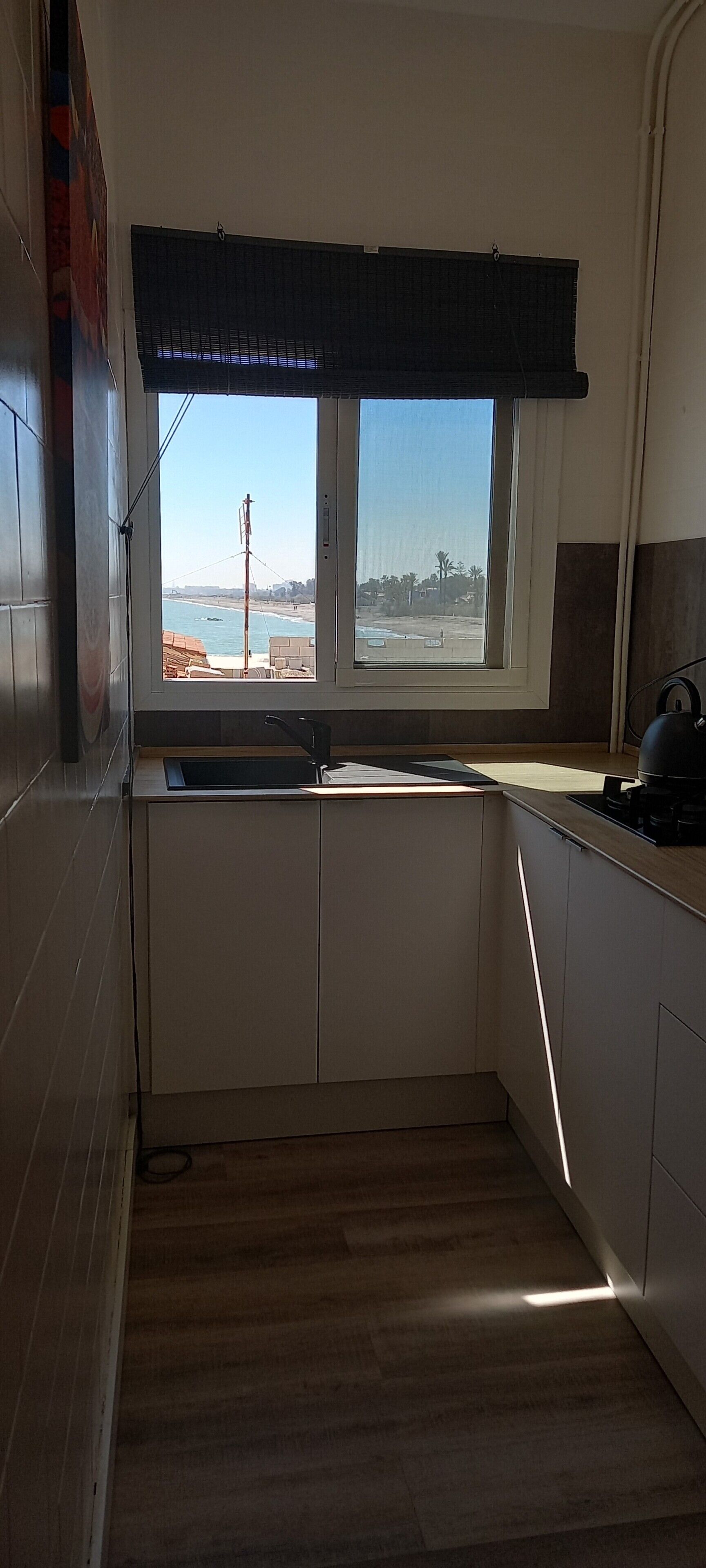 Una cocina con ventana, un lavabo y una estufa.