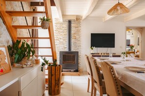 Un salon chaleureux avec une cheminée, des meubles en bois et un téléviseur fixé au mur.