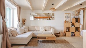 Un salon comprenant un canapé, une table basse, un meuble en bois et un grand miroir.