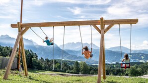 A wooden swing set with a clear view of mountains in the background.