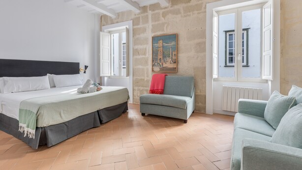 Ein Schlafzimmer mit Bett, einer Couch und einem Fenster mit Blick.