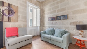 A living room with two sofas, a table, and artwork on the walls.