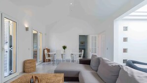 Ein modernes Wohnzimmer mit einer Couch, einem Couchtisch und einem Essbereich mit Tisch und Stühlen.