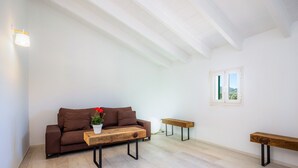 Una sala de estar moderna con un sofá marrón, una mesa de centro de madera y dos bancos.