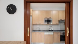 Eine Küche mit Holzausstattung, einer Mikrowelle, einem Spülbecken und einem Geschirrspüler.