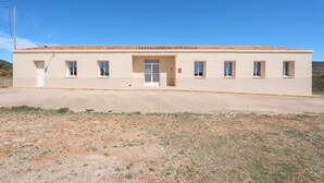 Un bâtiment d’un seul étage, doté d’un toit plat, d’une entrée centrale et de nombreuses fenêtres.
