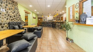 A restaurant with a stone wall, wooden tables, and cushioned seating. - Caravan 'Bungalow 2' with Mountain View, Wi-Fi and Air Conditioning (Alós de Balaguer)