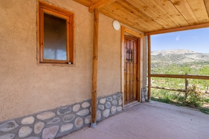 Un edificio con base de piedra, puerta de madera y ventana.