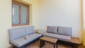 A corner room with a sofa, a small table, and a window. - Apartment 'Appartamento Superior Con Terrazza4' with Shared Pool, Wi-Fi and Air Conditioning (Castellammare del Golfo)