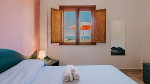 A bedroom with a bed, a nightstand, a mirror, and a window with open shutters. - Apartment 'Appartamento Superior Con Terrazza5' with Shared Pool, Wi-Fi and Air Conditioning (Castellammare del Golfo)