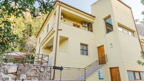 A multi-story building with a staircase, a balcony, and a sign indicating 'ARTIFACTS.' - Apartment 'Appartamento Superior Con Balcone8' with Shared Pool, Wi-Fi and Air Conditioning (Castellammare del Golfo)