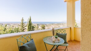 A balcony with a table and chairs, overlooking a cityscape and the sea. - Apartment 'Appartamento Superior Con Balcone8' with Shared Pool, Wi-Fi and Air Conditioning (Castellammare del Golfo)