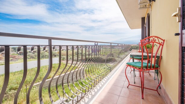 A balcony with a metal railing, a table with chairs, and a view of the landscape. - Apartment 'Medusa' with Balcony, Wi-Fi and Air Conditioning (Taormina)