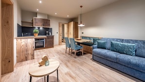 Une cuisine moderne avec des meubles en bois, un coin repas avec des chaises et un canapé bleu.