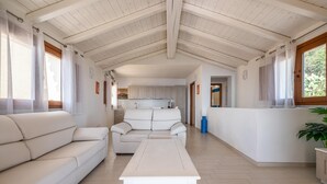 A spacious living area with a sofa, a coffee table, and a kitchen in the background.