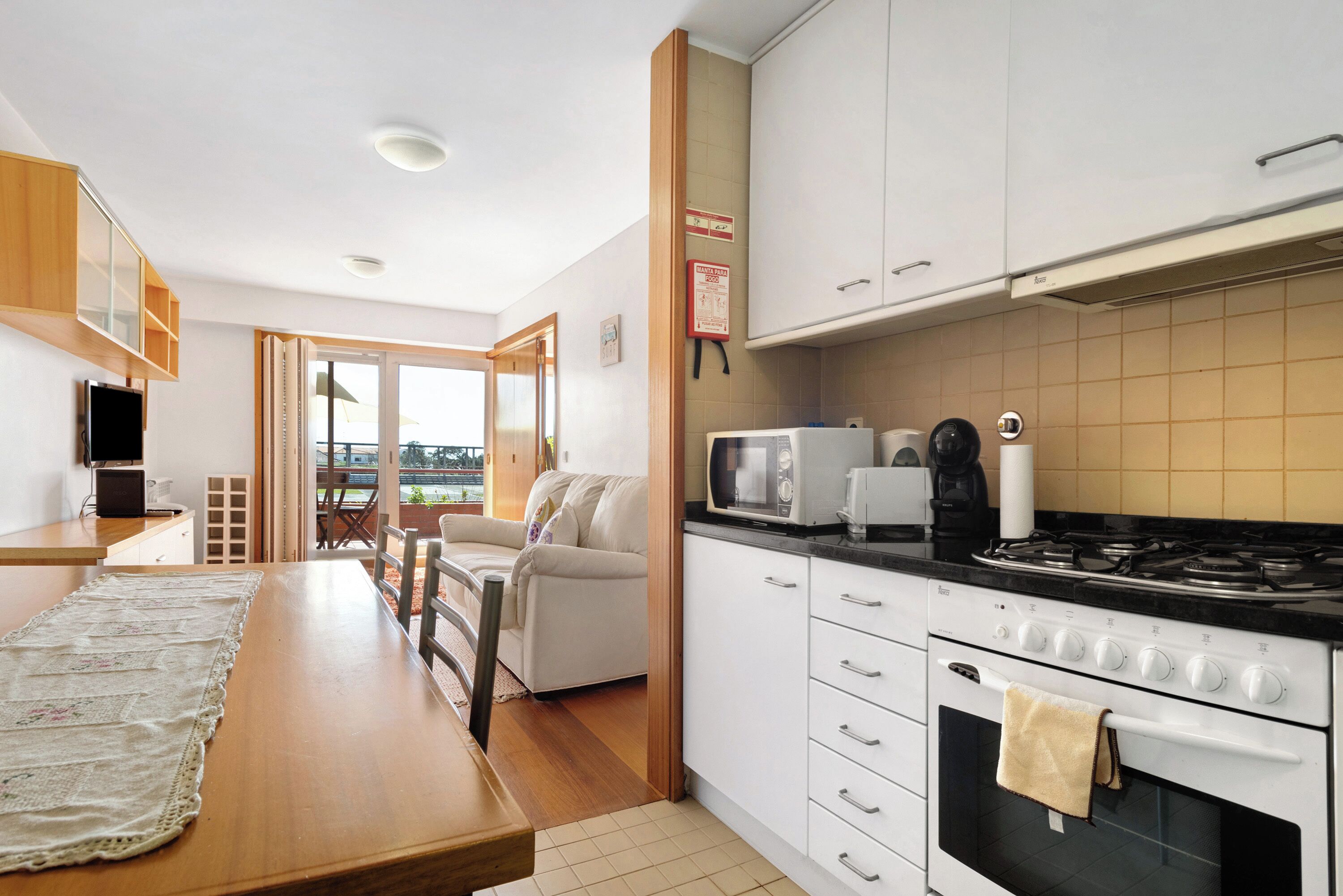 Een koelkast, een oven, een kookplaat, kookgerei, borden en bestek