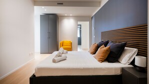 Une chambre à coucher moderne avec un lit, une table de chevet et une chaise.