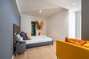 A modern bedroom with a bed, bedside table, and a yellow armchair.