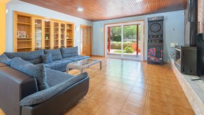 A living room with a sectional sofa, wooden cabinets, a dartboard, and a fireplace.