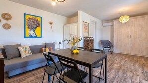 A modern living room with a dining table, chairs, a sofa, and a large wardrobe.