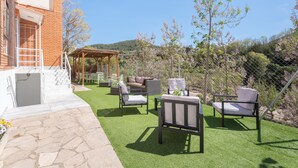 A patio with outdoor furniture, a pergola, and a view of a hilly landscape. - Chalet 'Castellana' with Mountain View, Wi-Fi and Air Conditioning (bicorp)