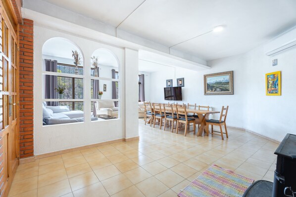 A spacious living area with a dining table, chairs, and a fireplace.