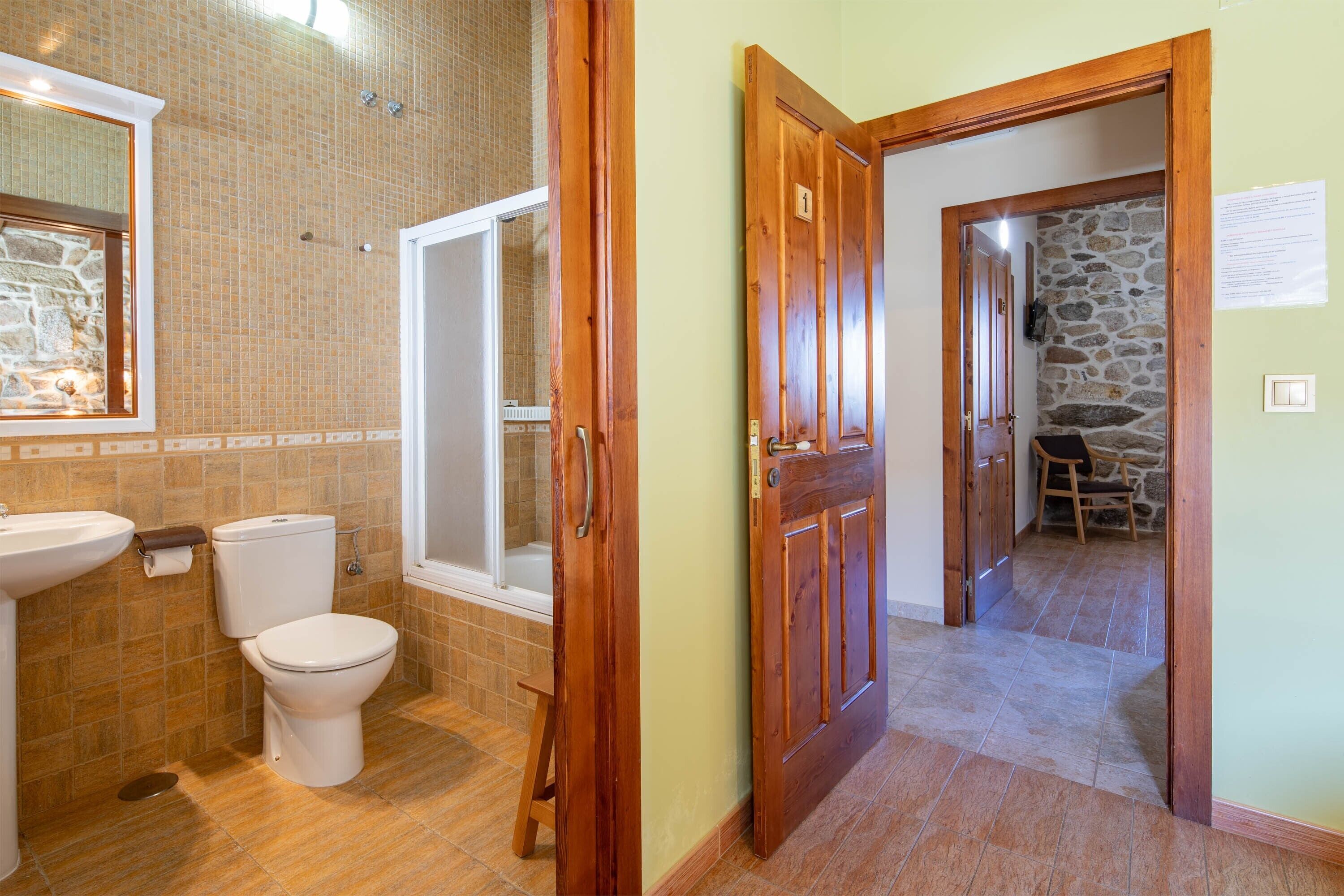 Une salle de bain comprenant des toilettes, un lavabo et une douche.