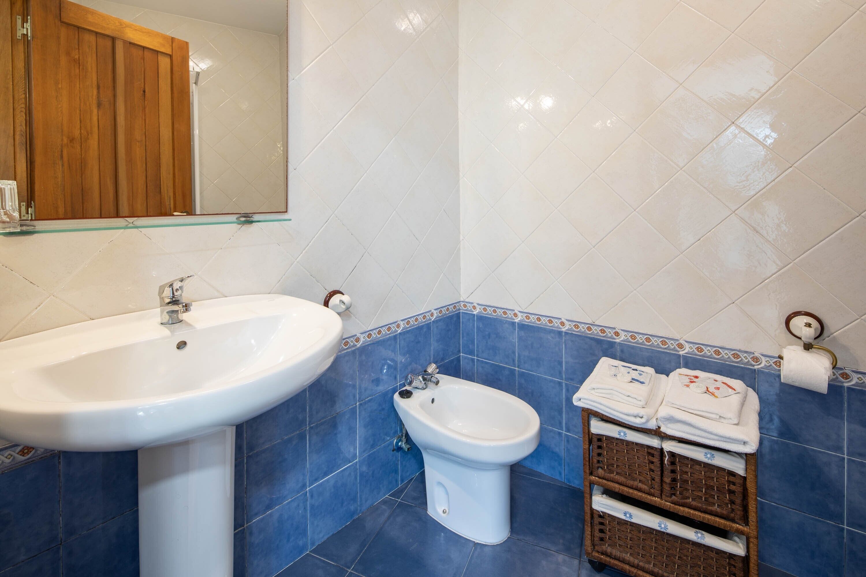 Une salle de bain équipée d’un lavabo, d’un bidet et d’un porte-serviettes avec des serviettes.