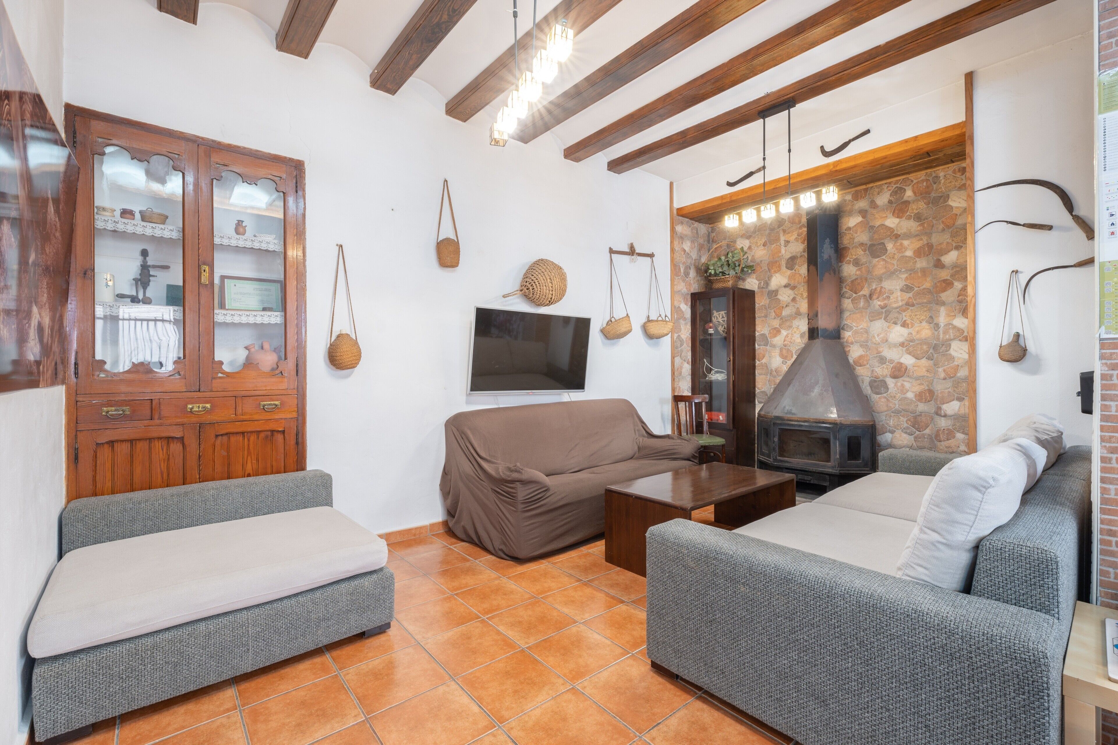Ein gemütliches Wohnzimmer mit Steinwand, Kamin und Fernseher.
