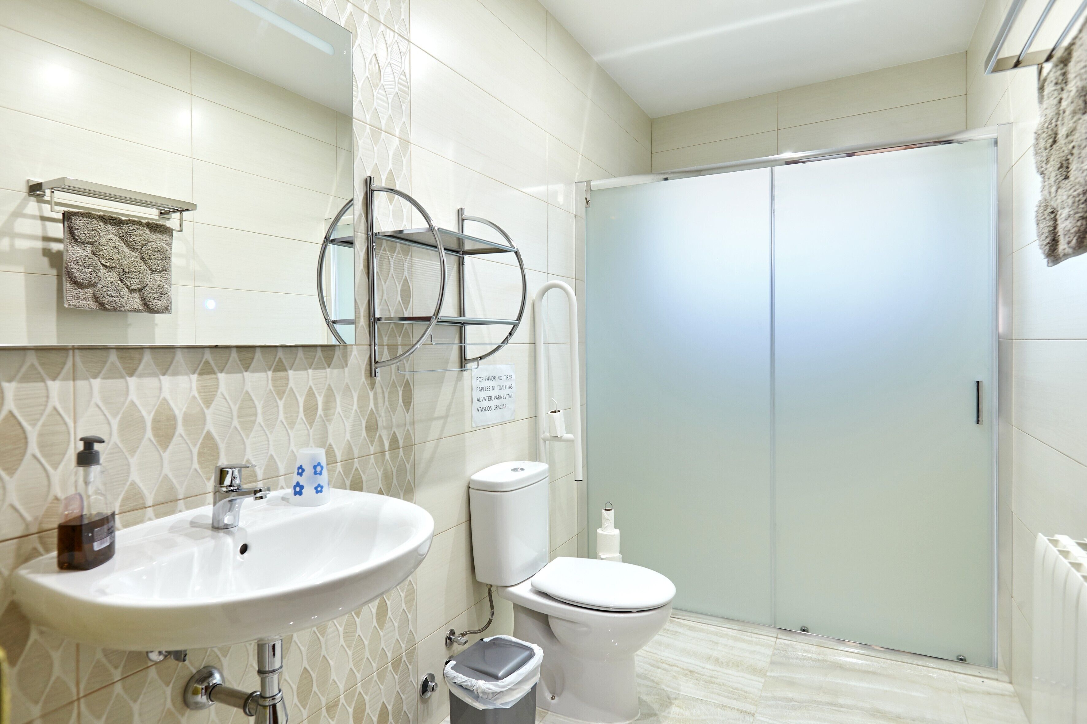 Un baño con lavabo, inodoro y perchero para toallas.
