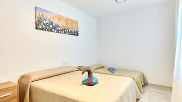 Un dormitorio con dos camas, un cuadro en la pared y un aparador de madera.