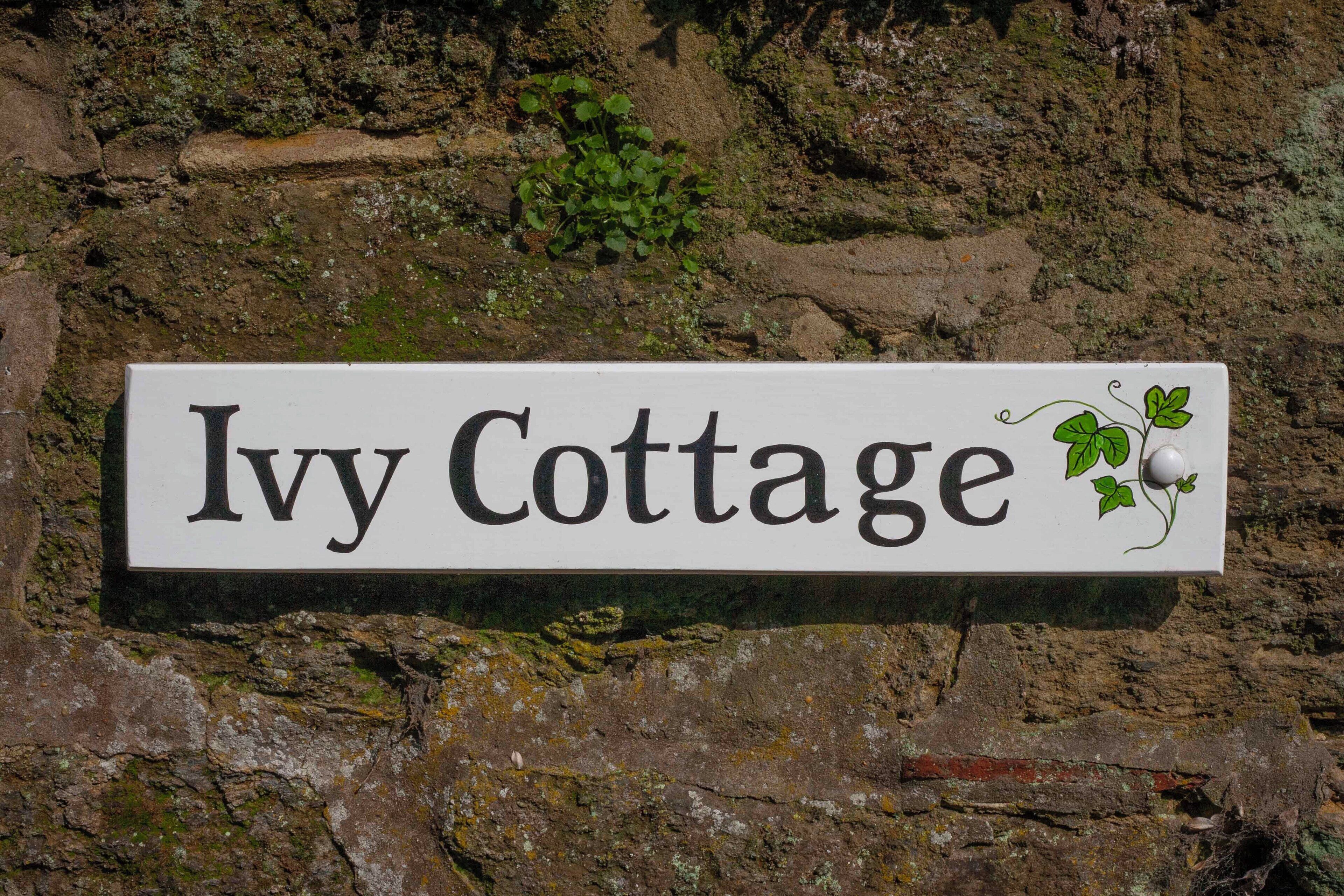 Un letrero para Ivy Cottage con una ilustración de hiedra.