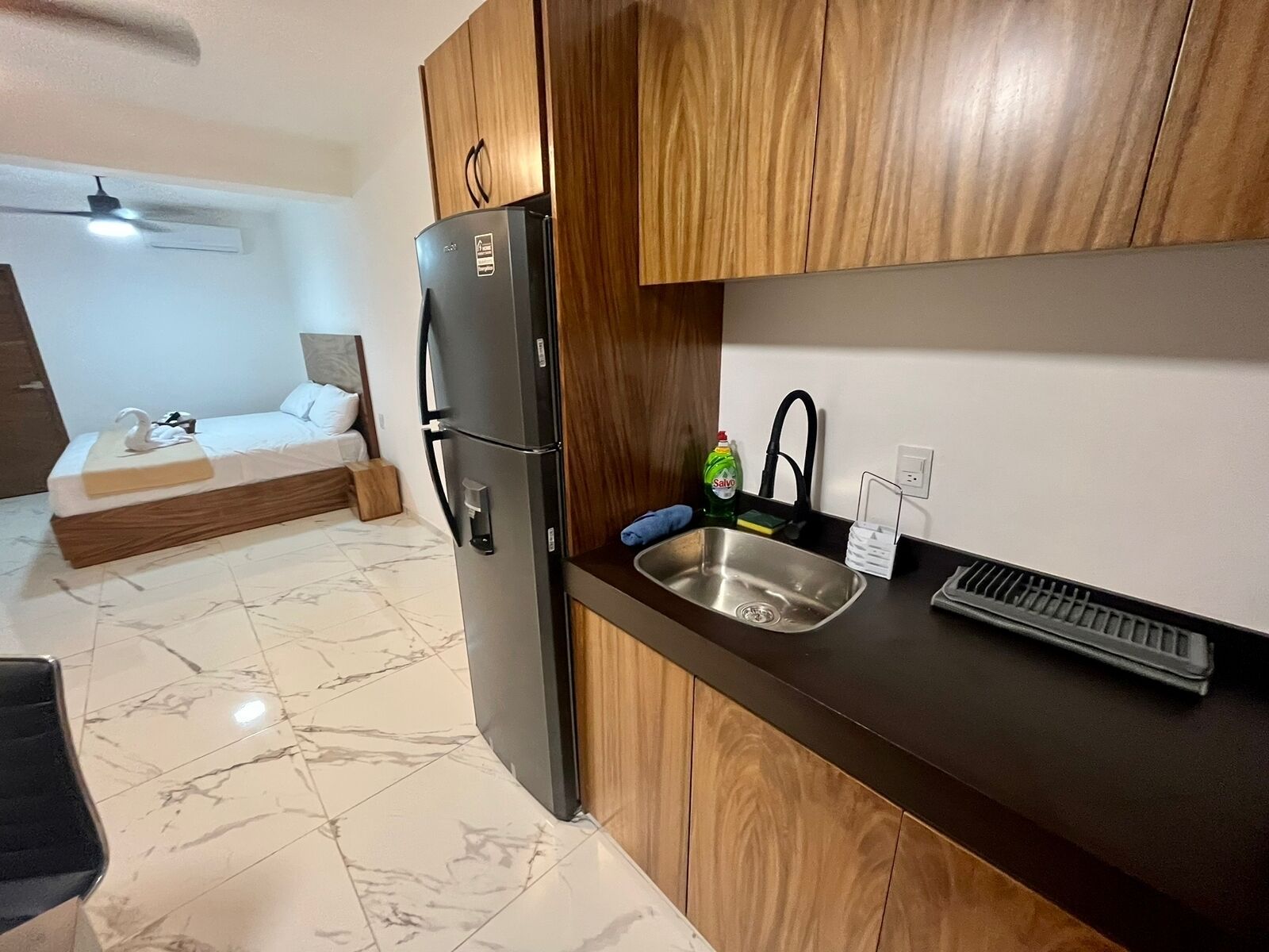 A compact kitchen with a built-in refrigerator, a sink, and a small countertop.
