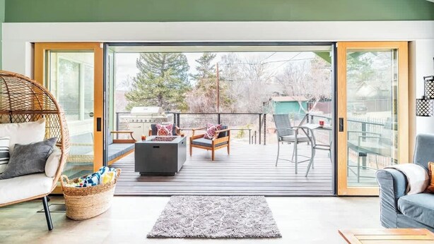 A modern living room with a large sliding glass door leading to an outdoor deck. - DT Flag | Epic Game Room | AC | Hot tub | Fire Pit (Flagstaff)