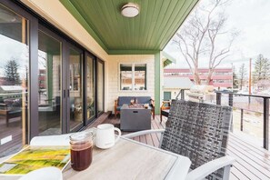 Un balcon avec une table, des chaises et un foyer.