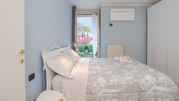 Une chambre avec un lit, un radiateur, un appareil de climatisation et une vue sur l’extérieur.