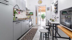 Una cocina moderna con armarios grises, encimera de madera y una zona de comedor con taburetes.