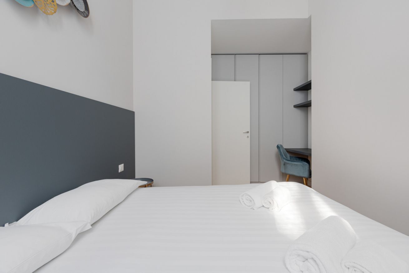 Une chambre d’hôtel moderne équipée d’un lit, d’un bureau et d’une armoire.
