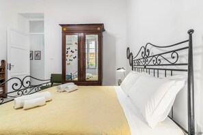 A hotel room with a bed, a wardrobe, a mirror, and a door.