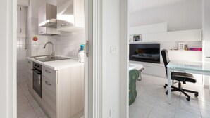 A modern kitchen with white cabinetry, a stainless steel sink, and a built-in oven. - GuestHost - Corvetto M3 - Bright Apt. with balcony! (Milano)