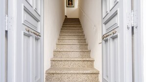 A staircase with white doors and a framed picture at the top. - GuestHost - Before Sunset Appealing Apartment with Terrace (Ostuni)