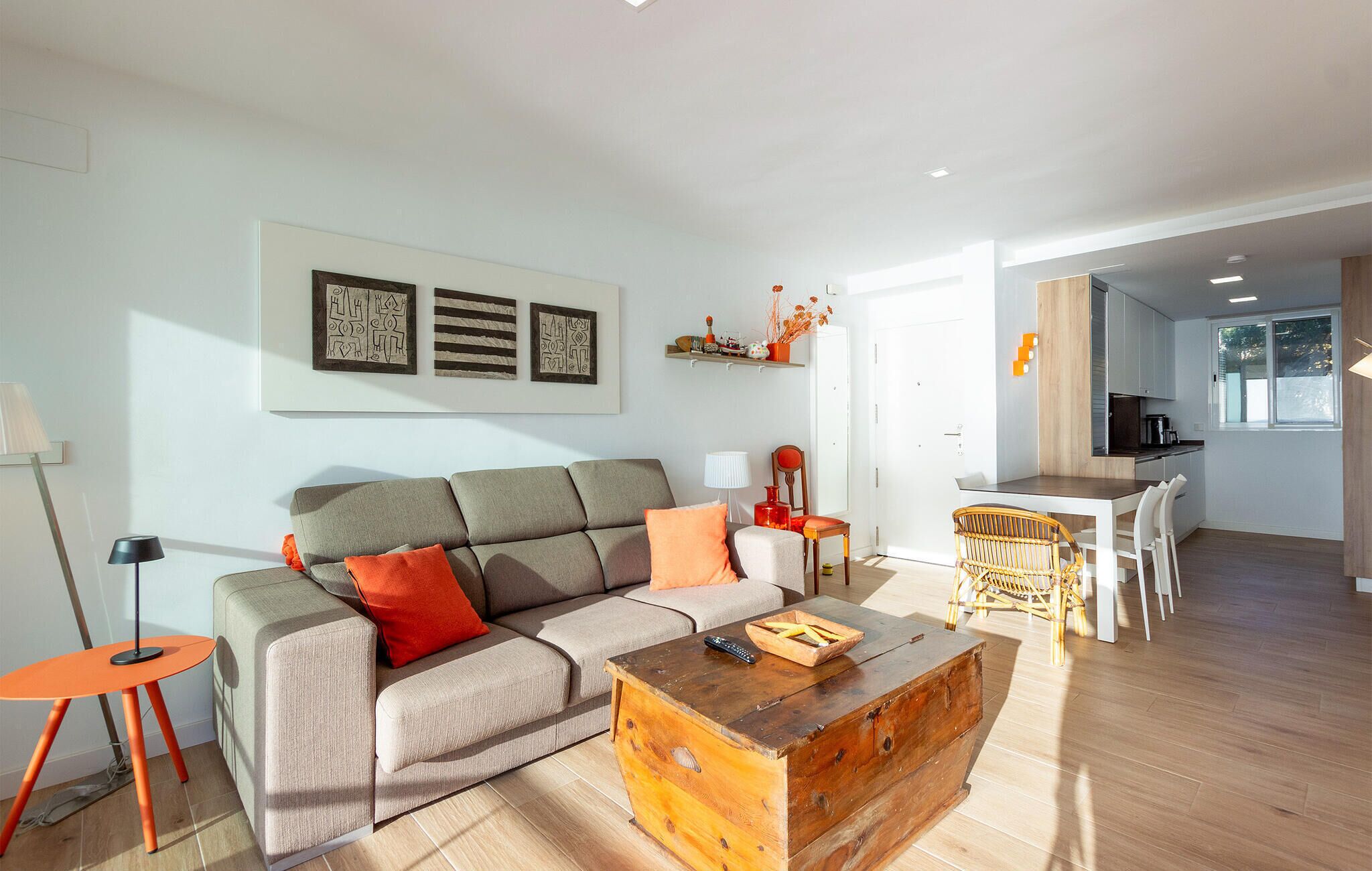 A modern living room with a sofa, coffee table, and dining area.